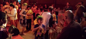 The riders, children, and staff enjoying a dance after the dinner at the end of the ride – Christina still wearing the garland given to her by the children.