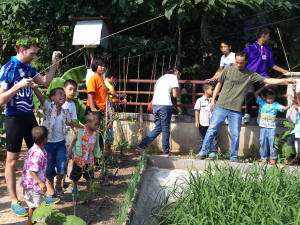Fishing for catfish with the children in the grounds of Home Hug, Mike Carr is being given help and instructions.